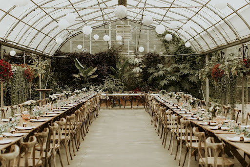 Wedding ceremony set up with wood chairs under a long wood pergola at the Saskatoon Farm.